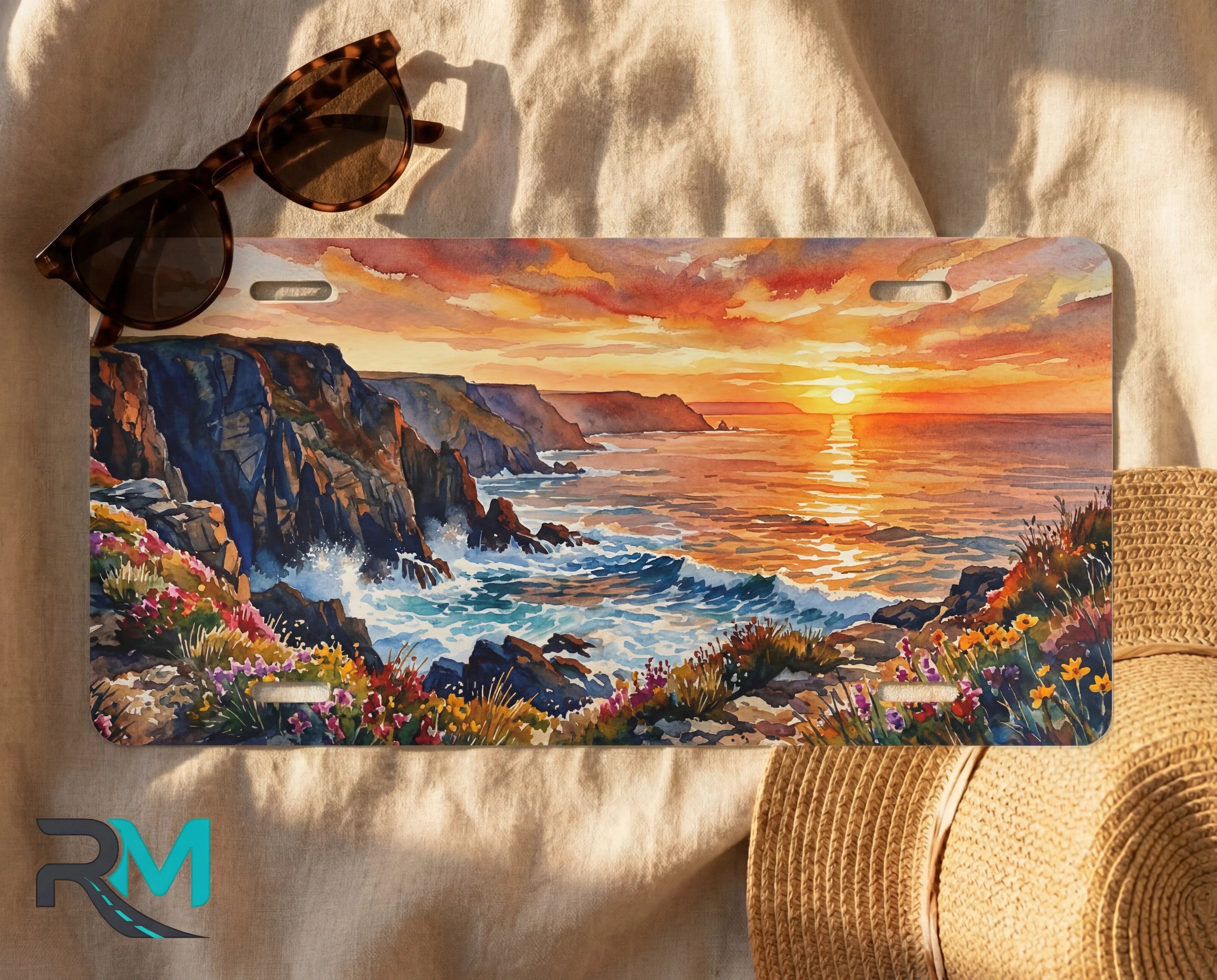 decorative coastal license plate flat lay — warm amber and violet sunset cliffs print