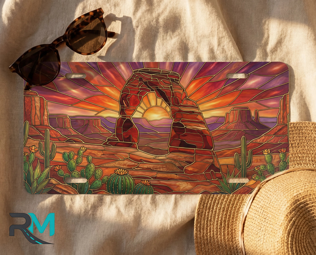 desert arch sunset license plate flat lay — warm amber sandstone arch cactus burning sunset front plate