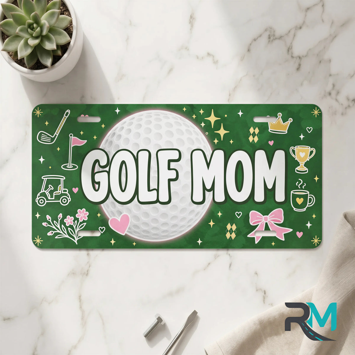 golf mom vanity plate on marble surface — deep green golf ball decorative license plate