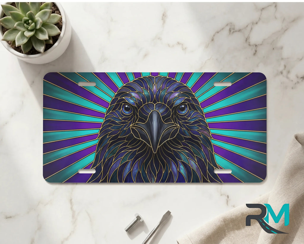 raven radiant rays vanity plate on marble surface — jewel-tone bird decorative license plate