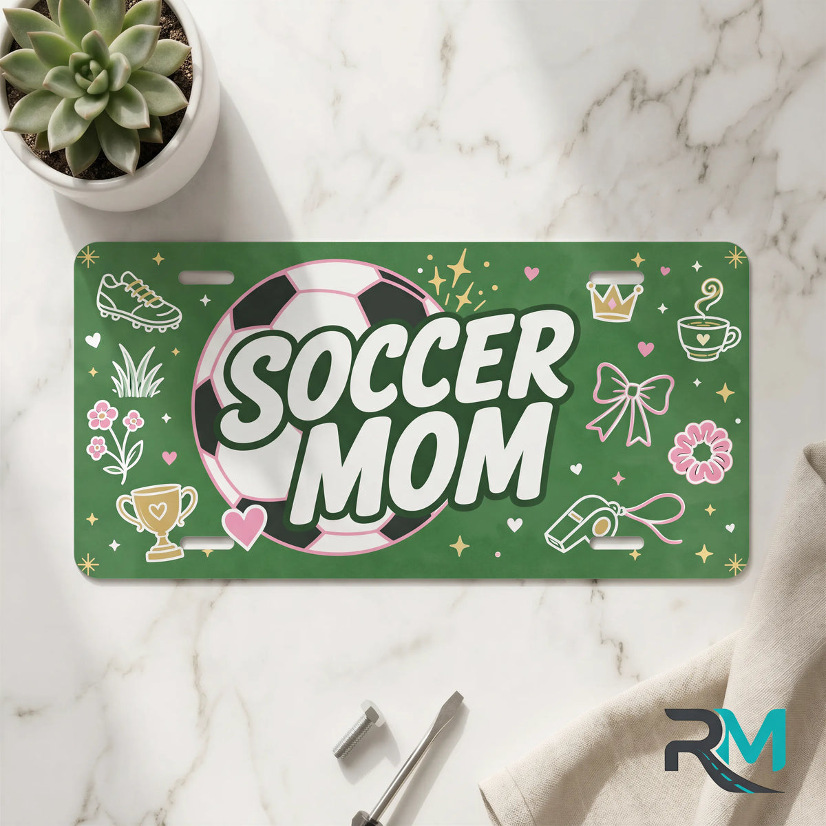 soccer mom vanity plate on marble surface — pink soccer ball green decorative license plate