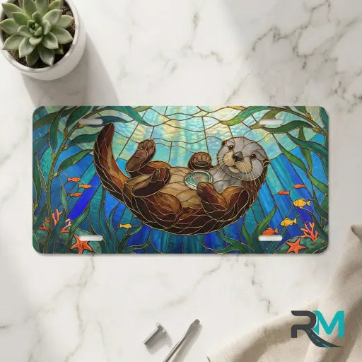 sea otter stained glass vanity plate on marble surface — jewel teal otter kelp decorative plate