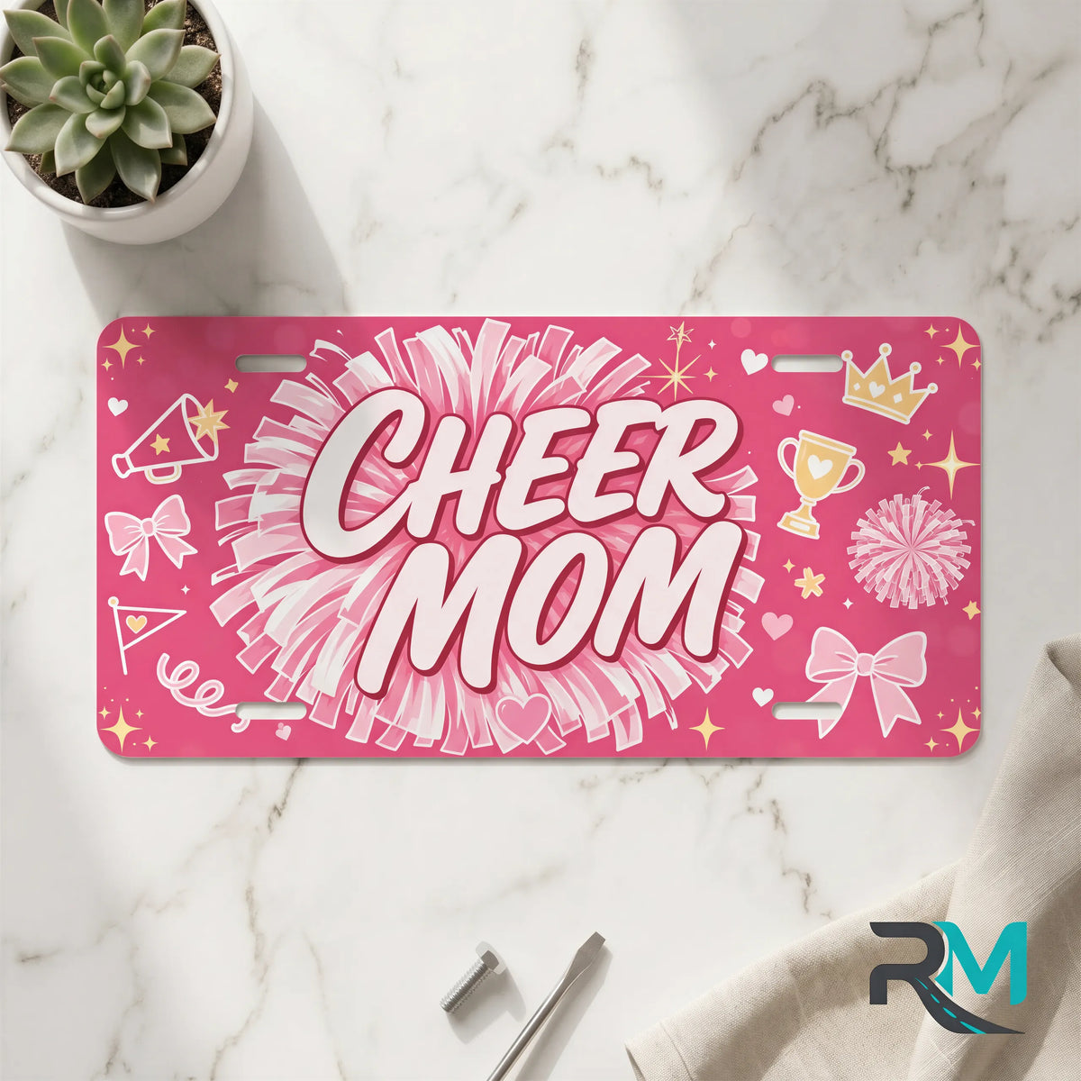 cheer mom vanity plate on marble surface — hot pink pom-pom decorative license plate