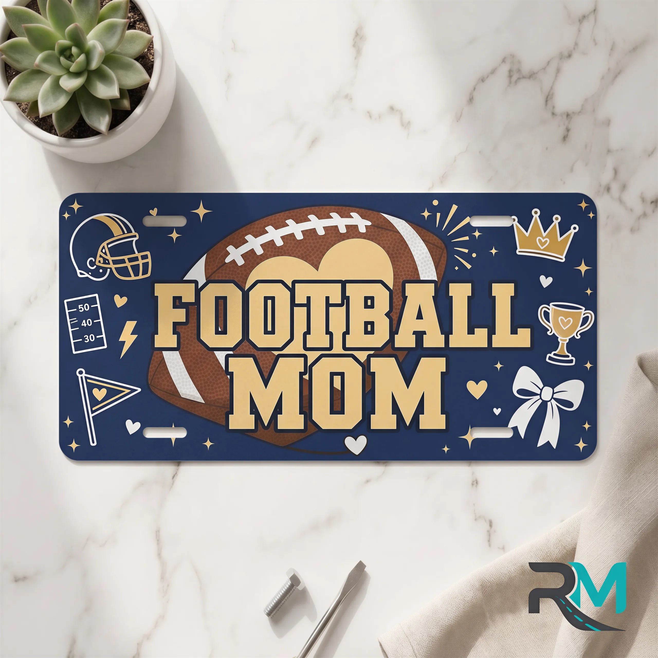 football mom vanity plate on marble surface — deep navy football decorative license plate
