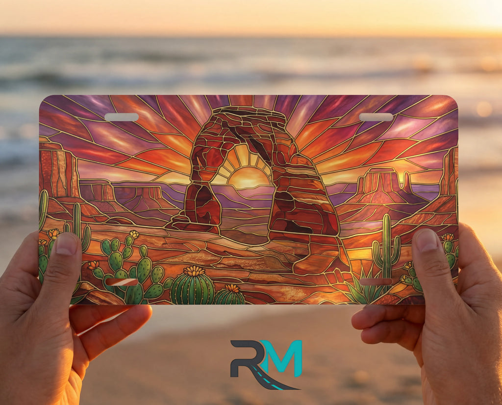person showing desert arch sunset vanity plate — warm amber sandstone arch cactus sunset front license plate