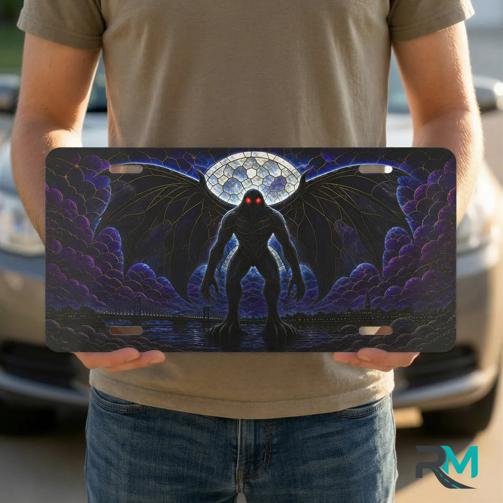 person holding mothman vanity plate — deep purple winged mothman cryptid front license plate