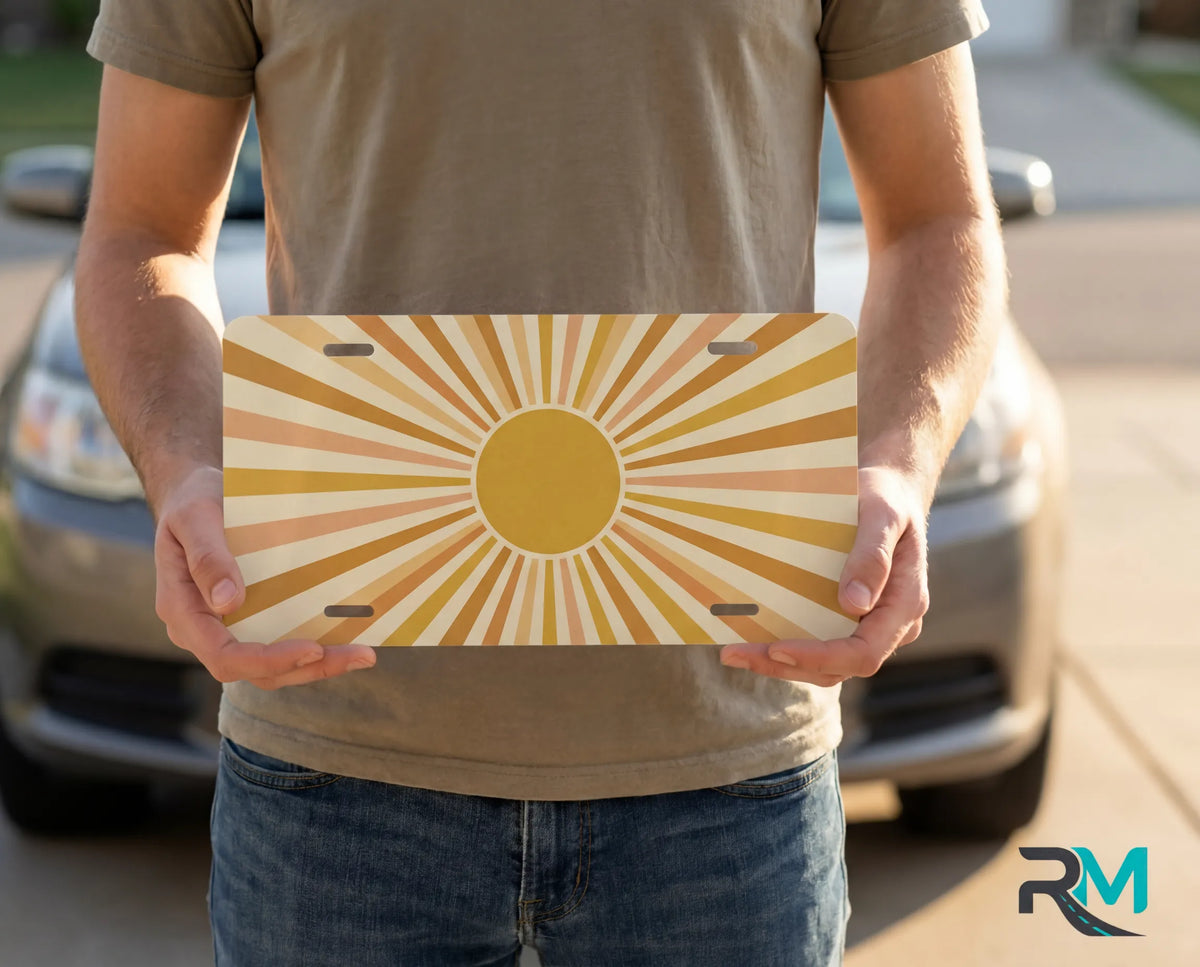 person holding retro yellow orange license plate — warm sunburst vanity plate boho art