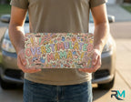 person holding overstimulated mama license plate — colorful pastel doodle vanity plate art