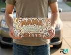 person holding mama needs coffee license plate — retro floral coffee vanity plate art