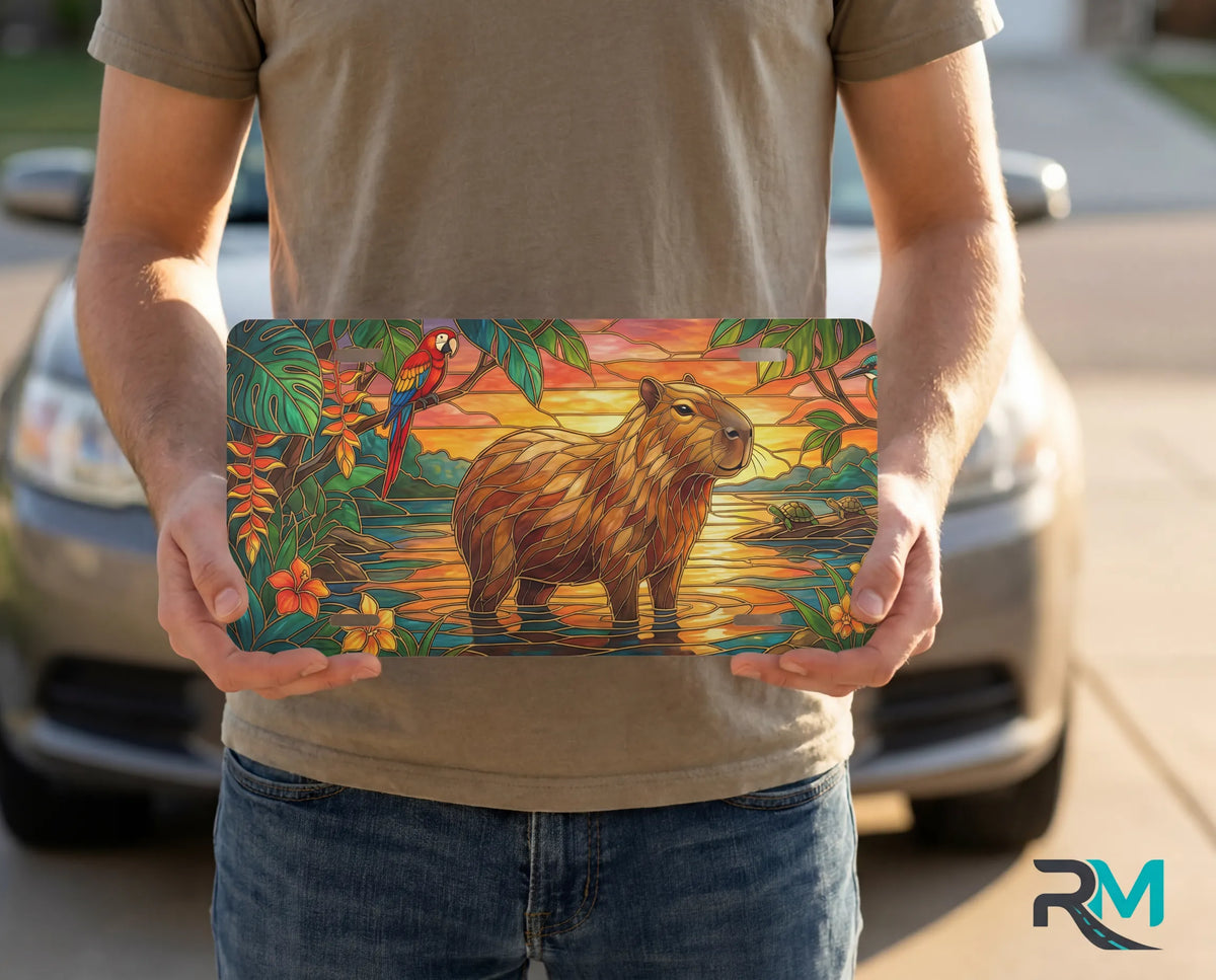 person showing capybara sunset vanity plate — golden capybara tropical parrot front license plate