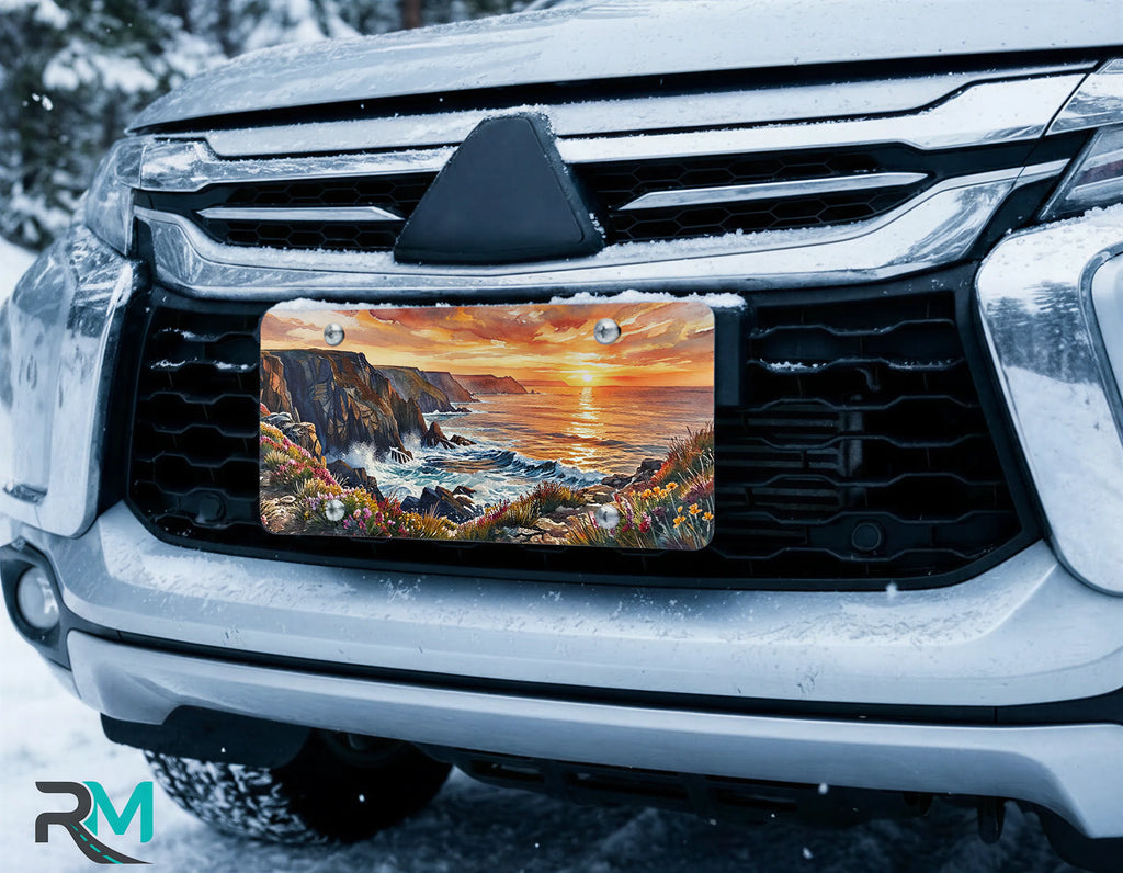 scenic front license plate on car in snowy setting — coastal cliffs sunset design