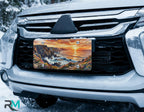 scenic front license plate on car in snowy setting — coastal cliffs sunset design