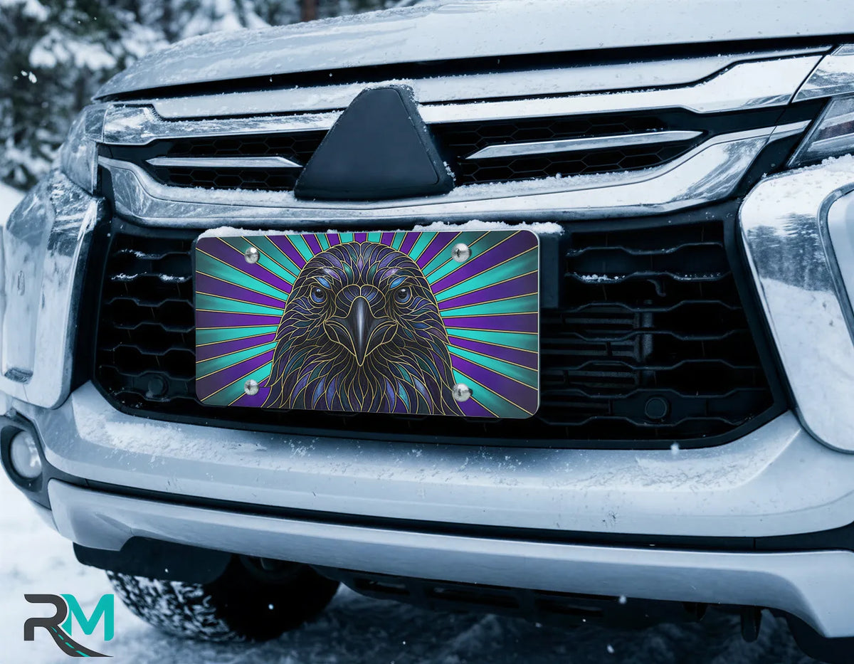 raven portrait license plate on car in snowy setting — jewel-tone blue teal bird design