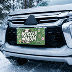 soccer mom license plate on car in snowy setting — pink ball green SOCCER MOM design