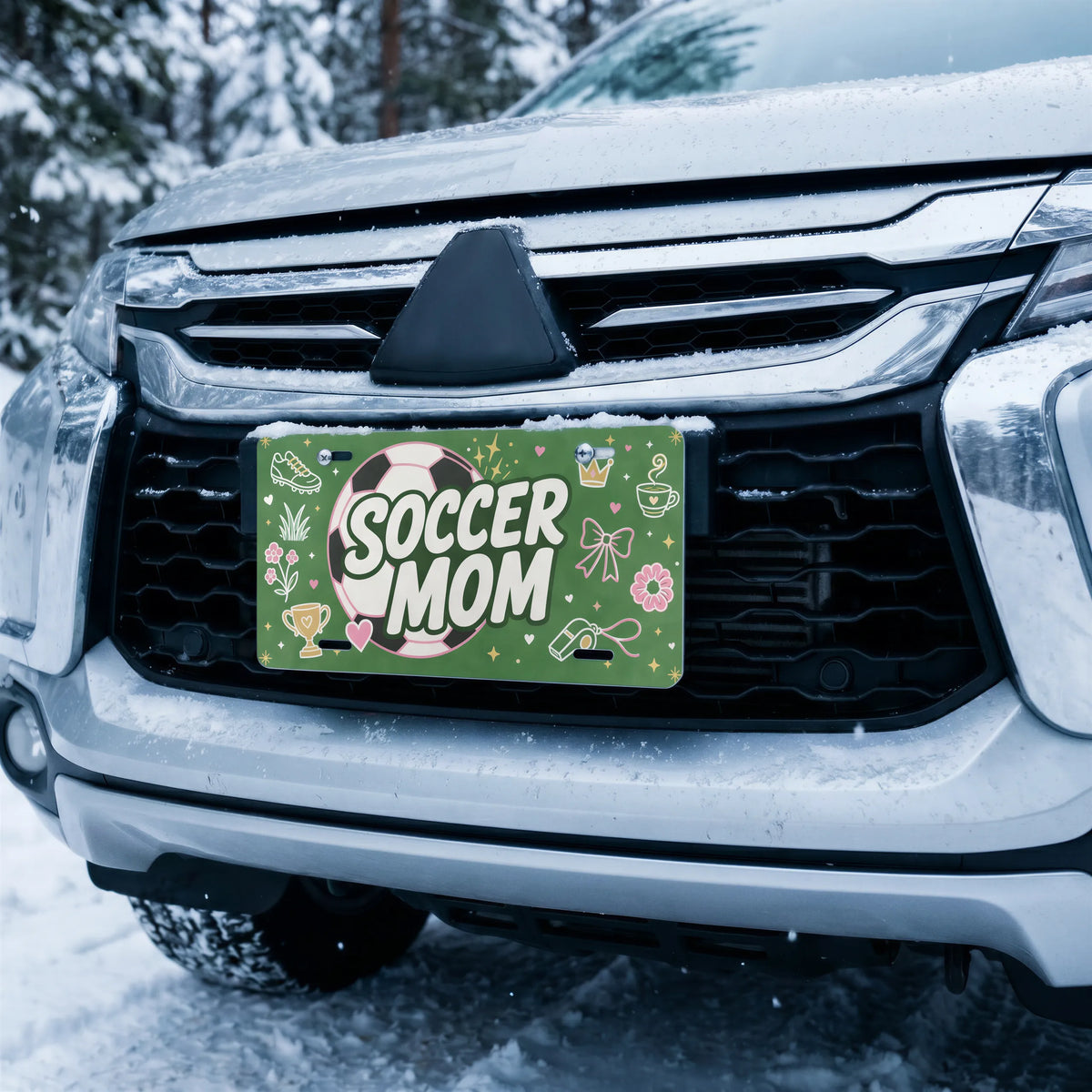 soccer mom license plate on car in snowy setting — pink ball green SOCCER MOM design