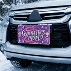gymnastics mom license plate on car in snowy setting — purple pink ribbon gymnastics design