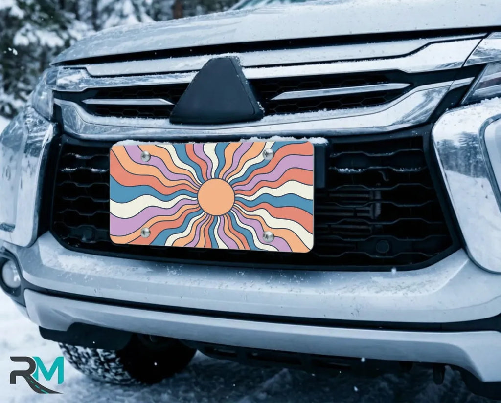 retro sunburst license plate on car in snowy setting — colorful boho sunset design
