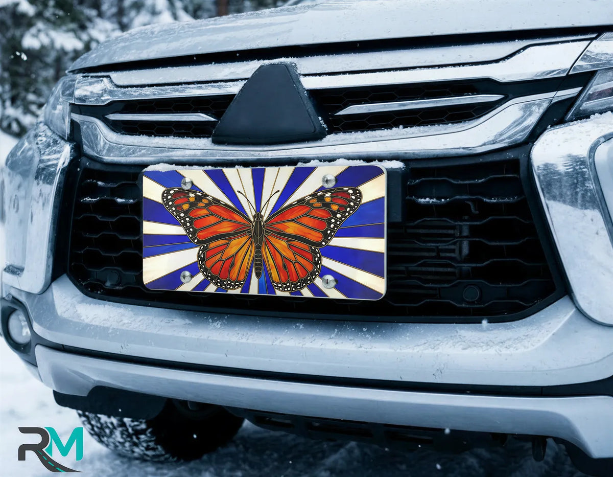butterfly license plate on car in snowy setting — monarch stained glass blue radial design