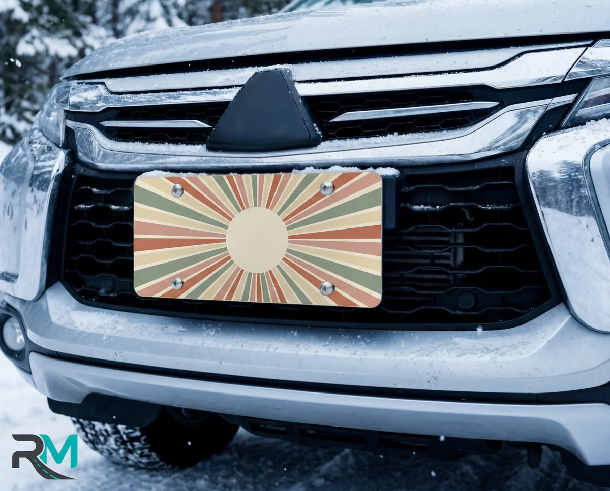 earth tone sunburst license plate on car in snowy setting — retro monogram circle design