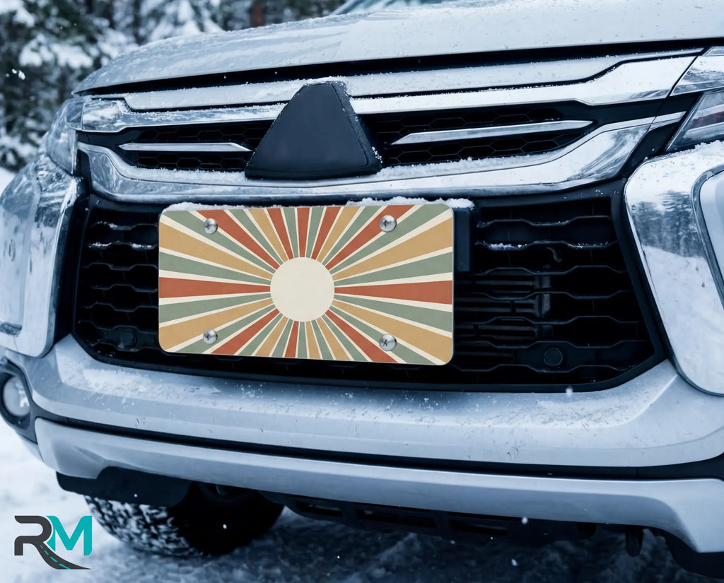 vintage rays license plate on car in snowy setting — retro earth tone sunburst design