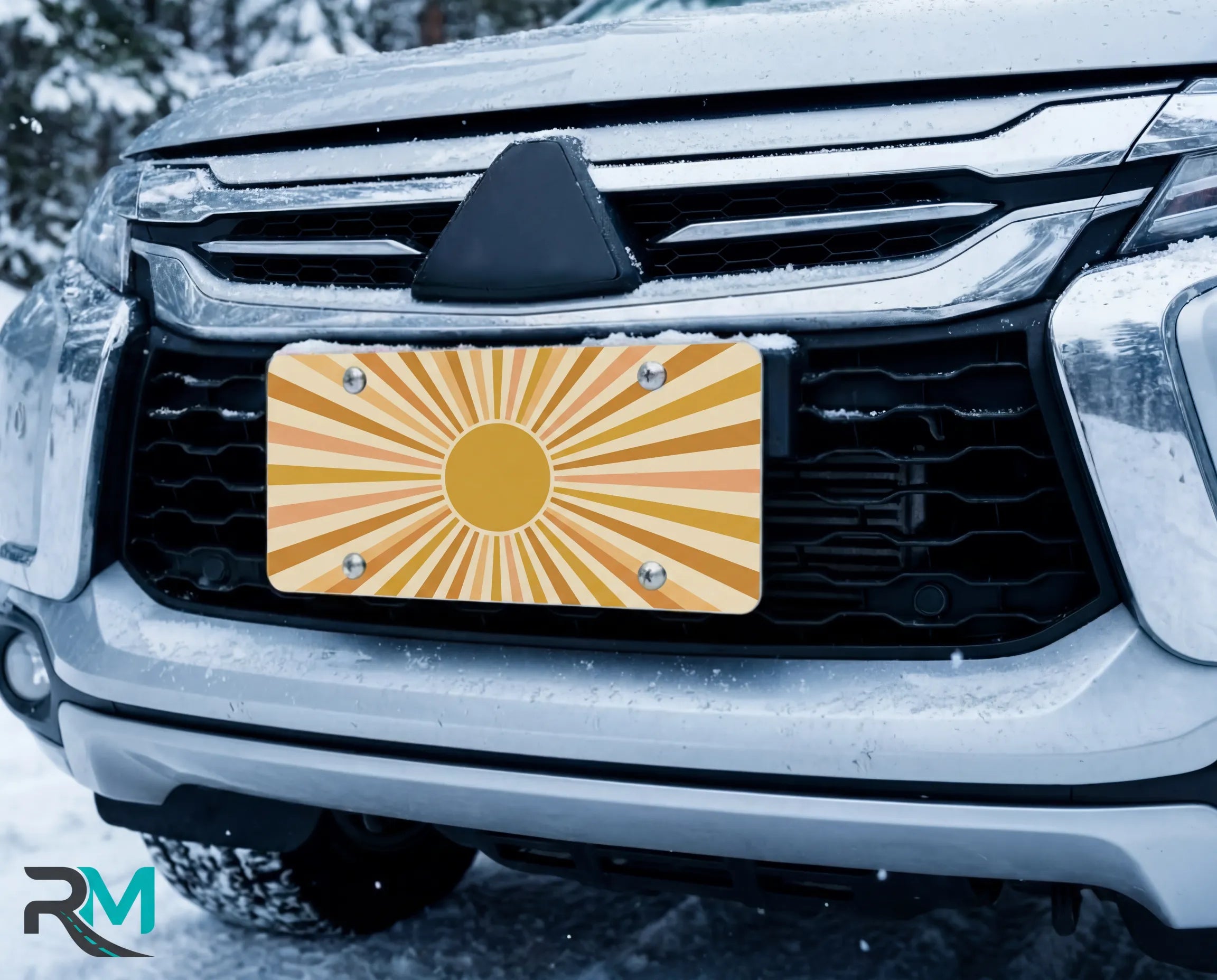 muted sunburst license plate on car in snowy setting — yellow orange retro design
