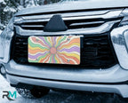 pastel rainbow license plate on car in snowy setting — dreamy swirling sunburst design