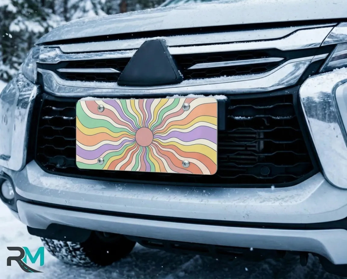 pastel rainbow license plate on car in snowy setting — dreamy swirling sunburst design