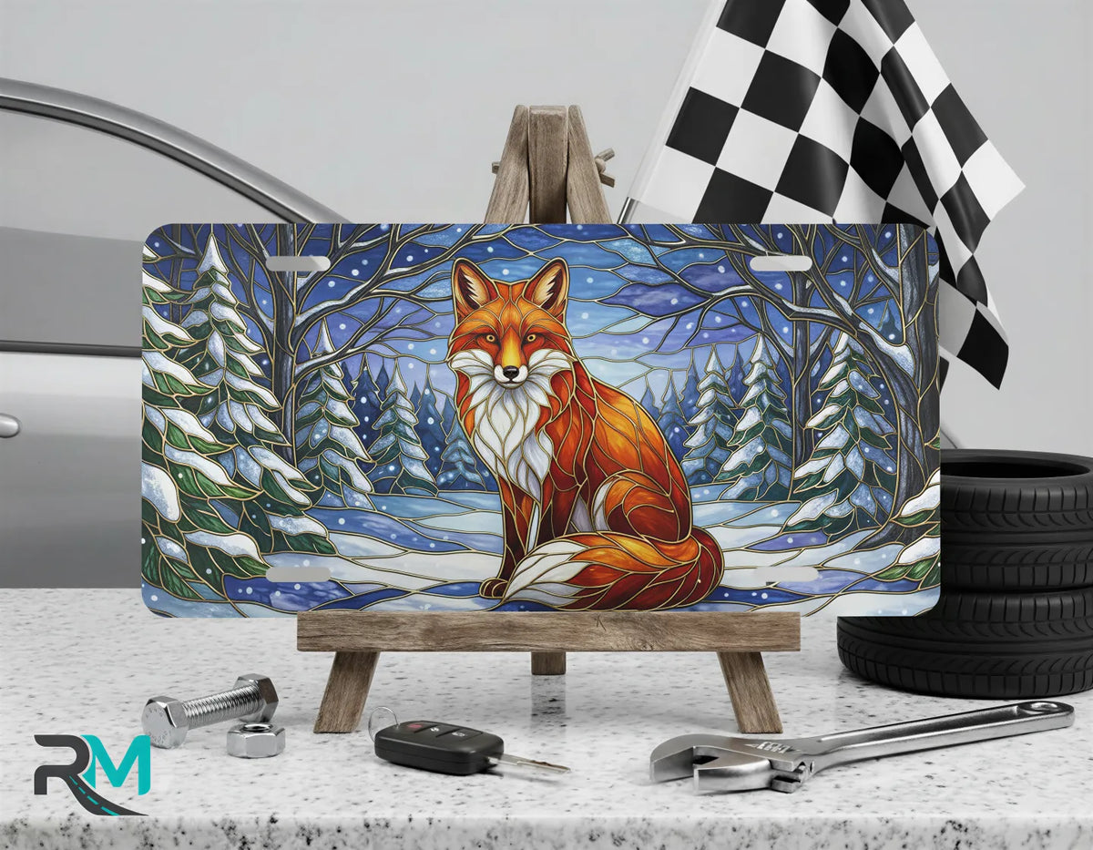 red fox winter vanity plate on display stand — warm amber snowy forest aluminum plate