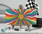 rainbow sunburst vanity plate on display stand — colorful retro aluminum license plate
