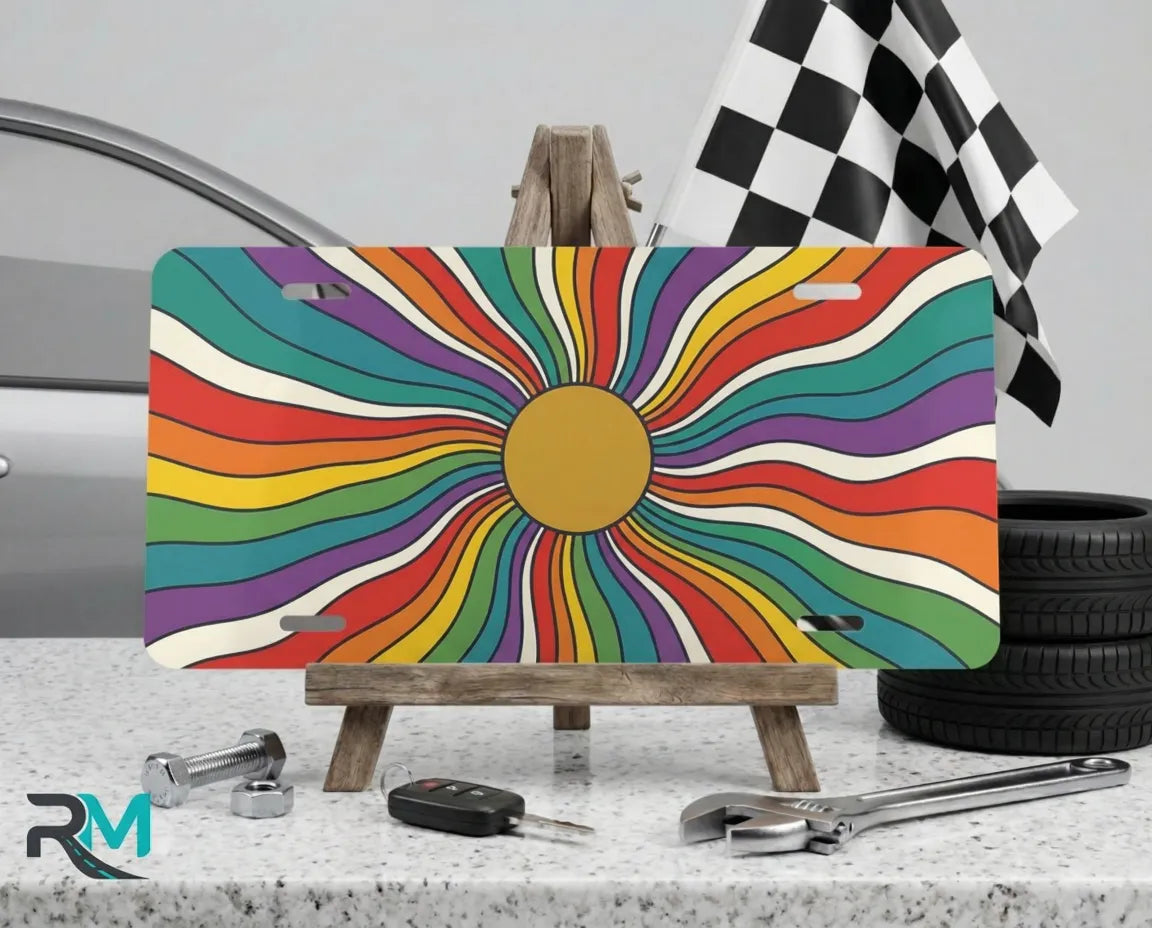 rainbow sunburst vanity plate on display stand — colorful retro aluminum license plate